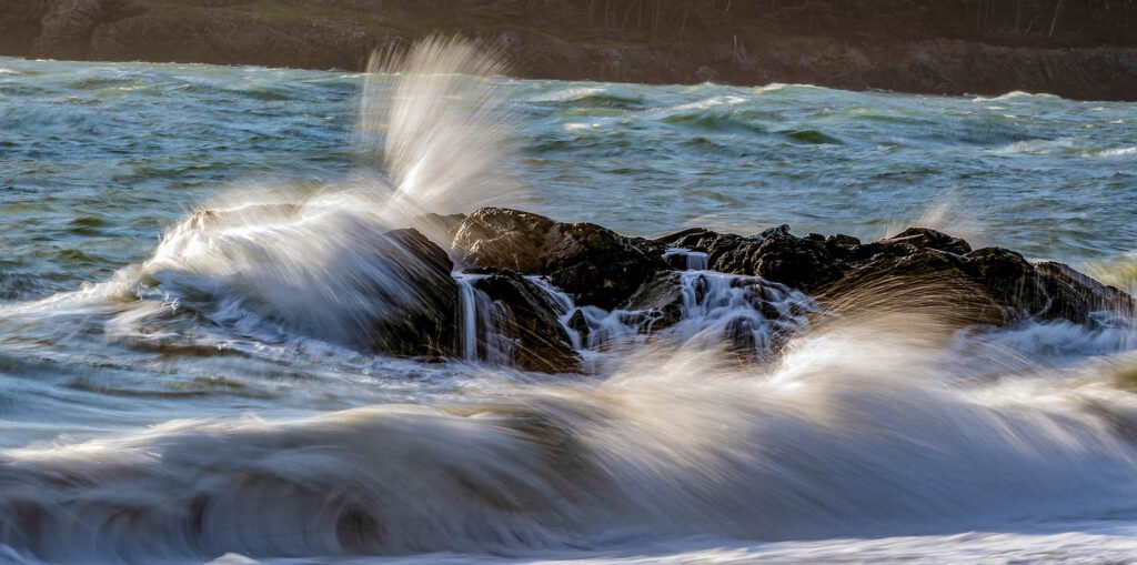 Waves crashing over rocks at West Beach, Deception Pass.